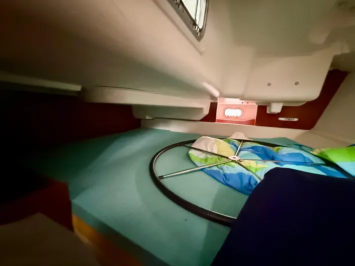  Yacht Photos Pics Interior cabin of 2012 Beneteau Oceanis 37 sailboat with colorful bedding and porthole.