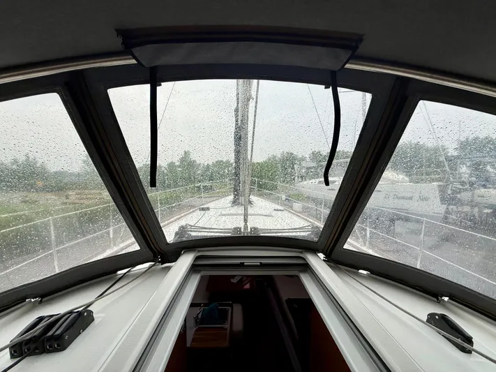  Yacht Photos Pics Interior view of 2012 Beneteau Oceanis 37 sailboat through rain-speckled windows.