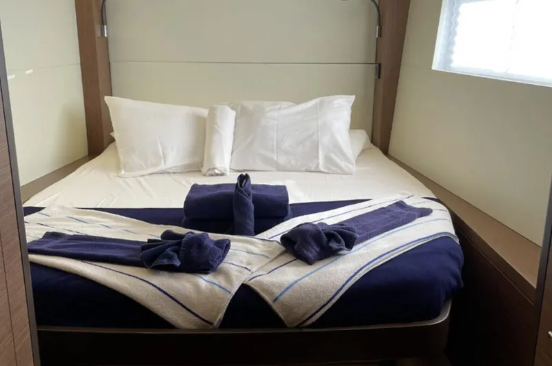 Skye Yacht Photos Pics Luxurious cabin interior of 2023 Lagoon 50 yacht with neatly arranged bed and towels.