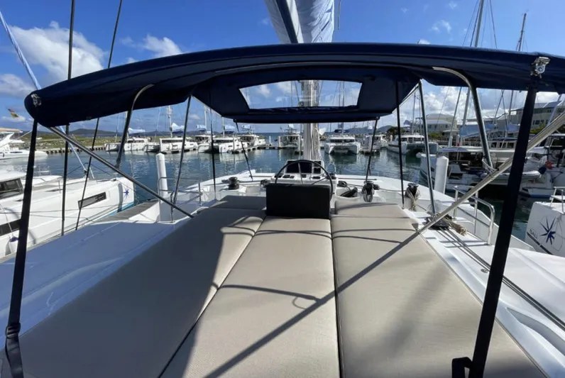 Skye Yacht Photos Pics 2023 Lagoon 50 catamaran with spacious deck and canopy in marina setting.