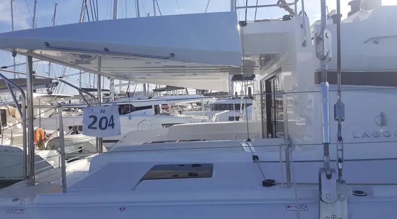 Skye Yacht Photos Pics 2023 Lagoon 50 catamaran docked at marina, side view with visible deck and canopy.