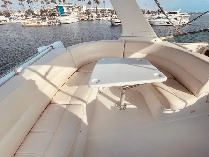  Yacht Photos Pics 1999 Carver Voyager yacht with white seating and table, docked in a marina.