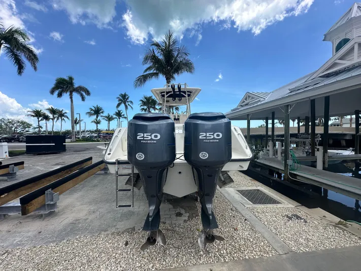  Yacht Photos Pics 2009 Pursuit C 310 Center Console boat with twin 250 horsepower engines docked under blue sky.