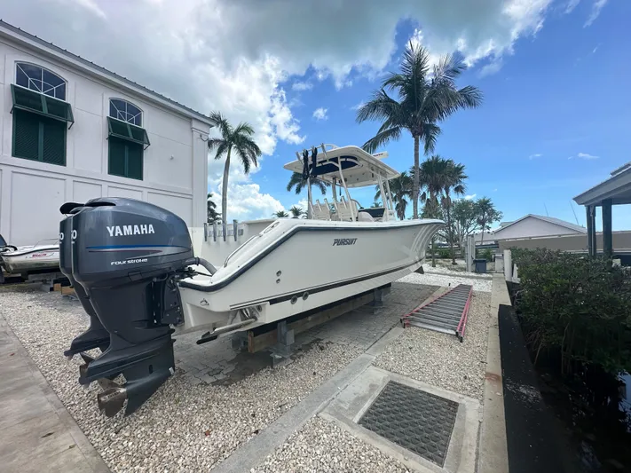  Yacht Photos Pics 2009 Pursuit C 310 Center Console boat with Yamaha engine, docked near palm trees.