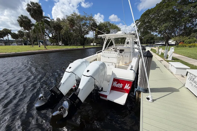 Watch Me Yacht Photos Pics 2008 Intrepid 350 Center Console boat docked by a scenic canal under a blue sky.