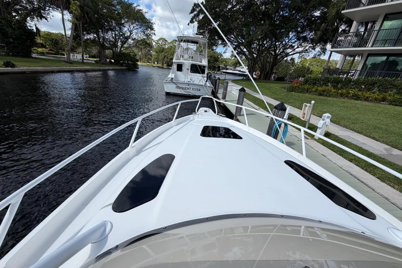 Watch Me Yacht Photos Pics 2008 Intrepid 350 Center Console docked on a serene waterway with lush greenery.
