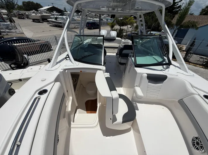 317-125 Yacht Photos Pics 2024 Robalo R317 Dual Console boat interior with seating and helm, docked outdoors.