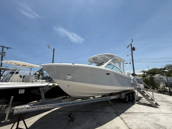 317-125 Yacht Photos Pics 2024 Robalo R317 Dual Console boat on trailer under clear blue sky.