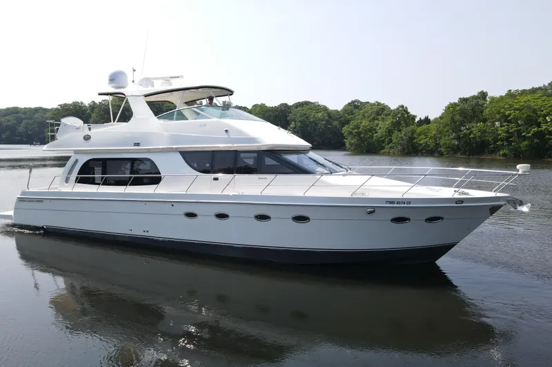 Mardi Gras Yacht Photos Pics 2006 Carver 56 Voyager yacht cruising on a serene lake with lush green surroundings.