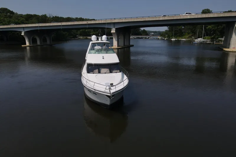 Mardi Gras Yacht Photos Pics 2006 Carver 56 Voyager yacht on calm river under bridge.