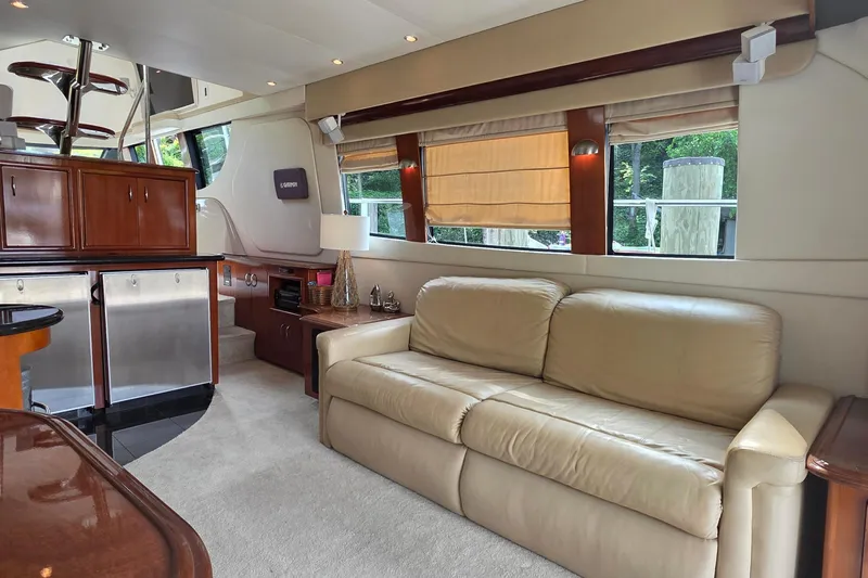 Mardi Gras Yacht Photos Pics Luxurious interior of 2006 Carver 56 Voyager yacht with beige sofa and wooden accents.