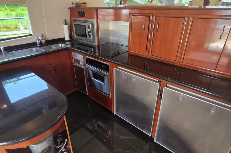 Mardi Gras Yacht Photos Pics Luxurious kitchen in 2006 Carver 56 Voyager yacht with sleek wood cabinetry and modern appliances.