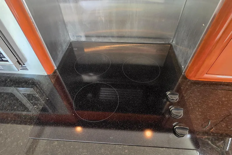 Mardi Gras Yacht Photos Pics Stovetop in 2006 Carver 56 Voyager yacht kitchen with sleek black finish.