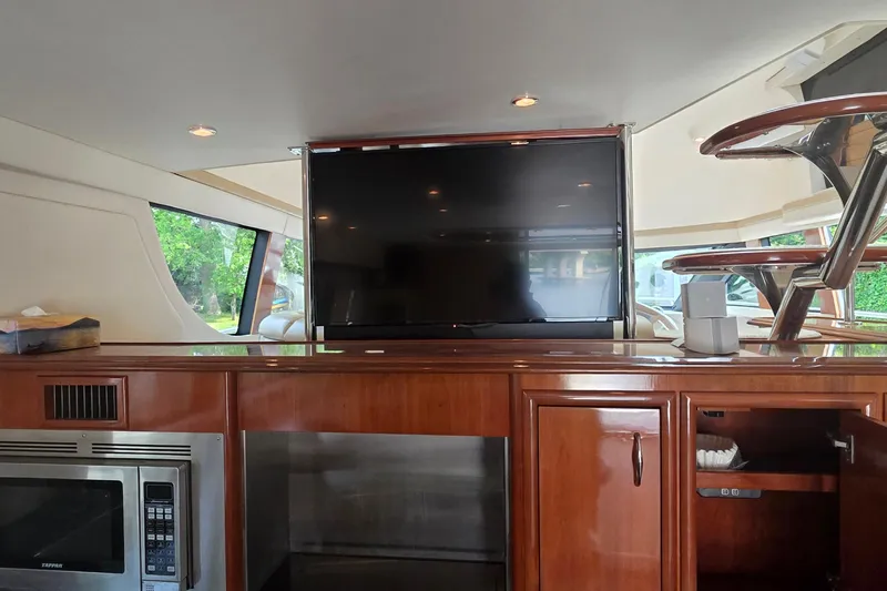 Mardi Gras Yacht Photos Pics Interior of 2006 Carver 56 Voyager yacht with TV, microwave, and wooden cabinetry.