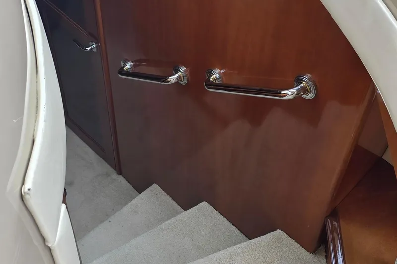 Mardi Gras Yacht Photos Pics Staircase with wooden paneling and chrome handles on a 2006 Carver 56 Voyager yacht.