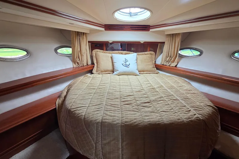 Mardi Gras Yacht Photos Pics Luxurious bedroom interior of 2006 Carver 56 Voyager yacht with elegant bedding and porthole windows.