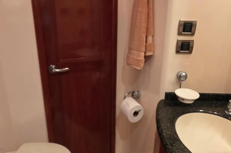 Mardi Gras Yacht Photos Pics Bathroom interior of 2006 Carver 56 Voyager yacht with sink and wooden door.