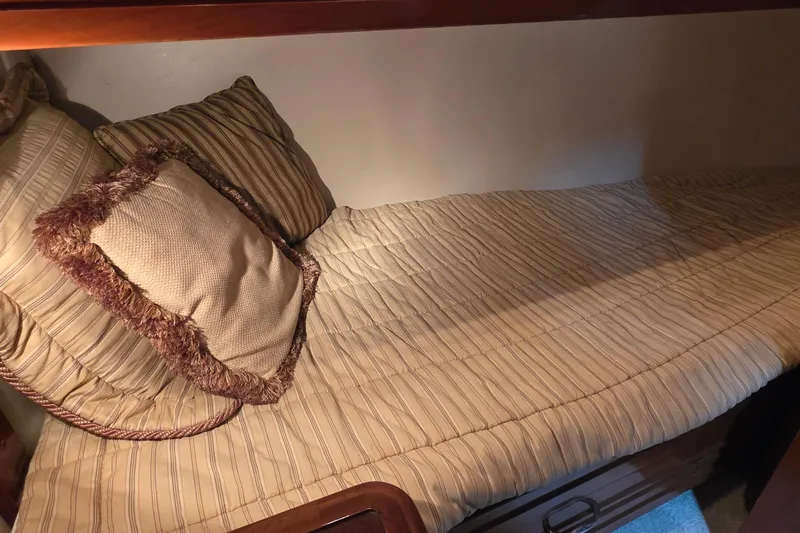 Mardi Gras Yacht Photos Pics Cozy cabin bed in 2006 Carver 56 Voyager yacht with striped bedding and decorative pillow.