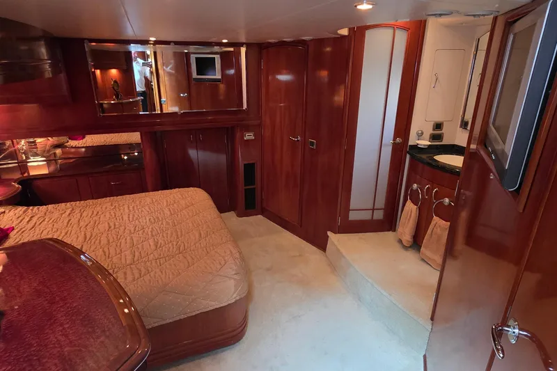 Mardi Gras Yacht Photos Pics Luxurious interior of 2006 Carver 56 Voyager yacht with wood finishes and cozy bedroom.