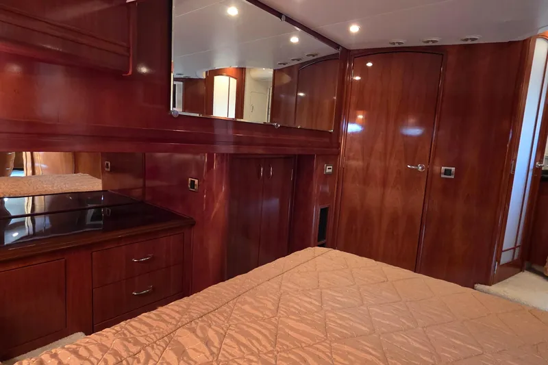 Mardi Gras Yacht Photos Pics Luxurious 2006 Carver 56 Voyager yacht interior with elegant wood finish and cozy bedding.