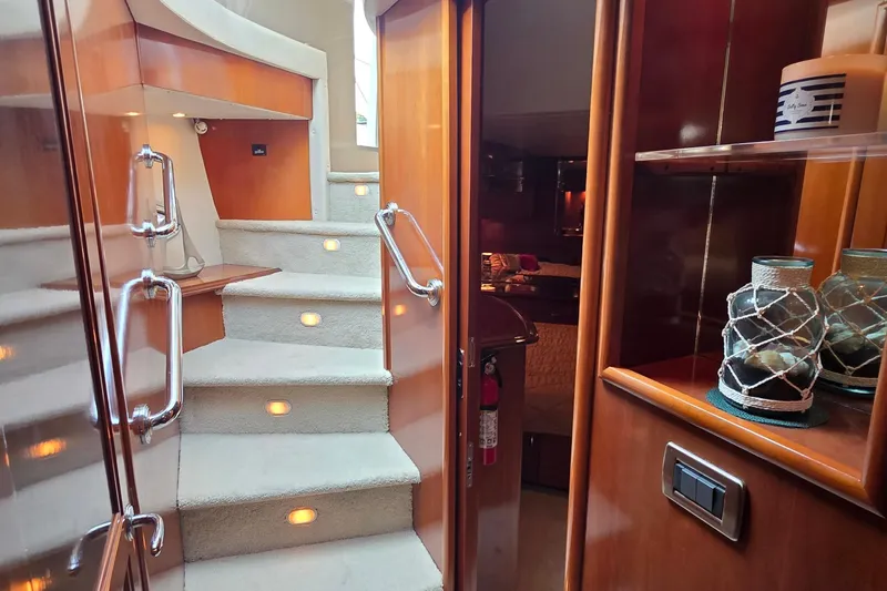 Mardi Gras Yacht Photos Pics Luxurious interior of 2006 Carver 56 Voyager yacht with carpeted stairs and elegant wood finishes.