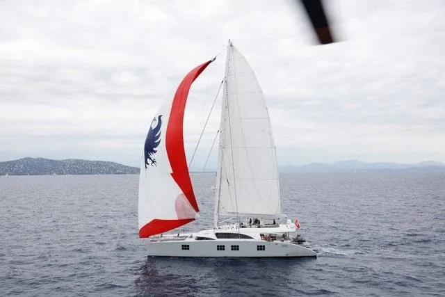 Ipharra Yacht Photos Pics Luxury Sunreef 31m yacht sailing with vibrant spinnaker, 2009 model, on open sea.