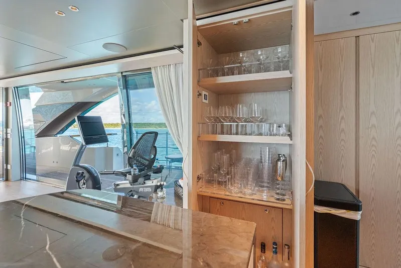 The Wolf Yacht Photos Pics Luxurious 2023 Sanlorenzo SD118 yacht interior with glassware cabinet and exercise bike.