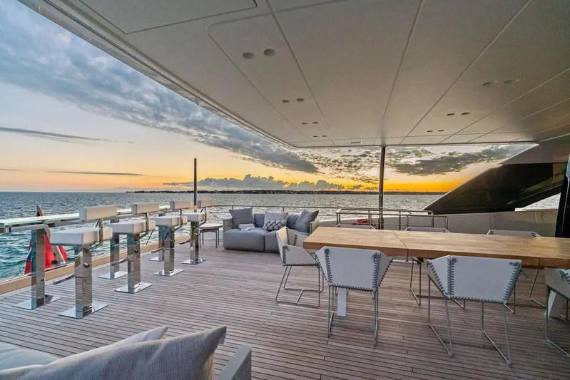The Wolf Yacht Photos Pics Luxurious 2023 Sanlorenzo SD118 yacht deck with elegant seating, ocean view, and sunset backdrop.