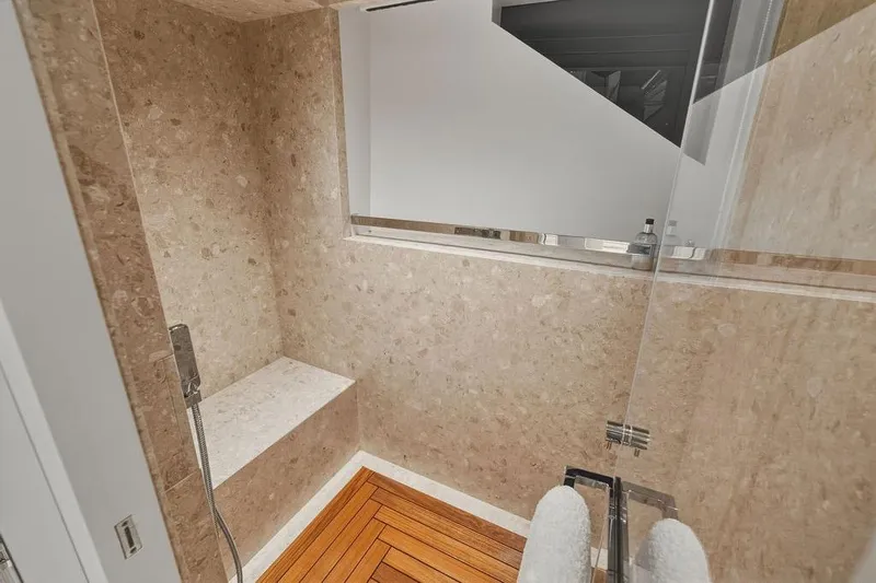 The Wolf Yacht Photos Pics Luxurious shower in 2023 Sanlorenzo SD118 yacht with marble walls and wooden floor.