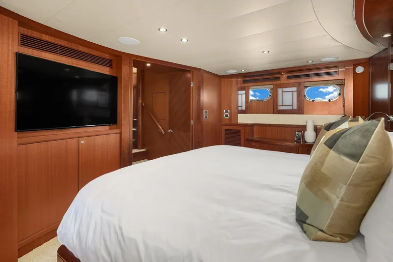 Estancia Yacht Photos Pics Luxurious bedroom interior of 2010 Ocean Alexander 80 Motoryacht with wood paneling and large TV.