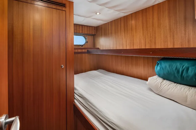 Estancia Yacht Photos Pics Cozy cabin interior of 2010 Ocean Alexander 80 Motoryacht with wooden paneling and bedding.