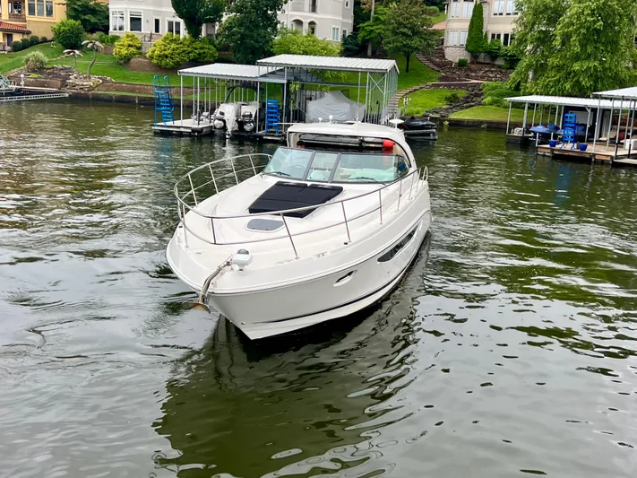  Yacht Photos Pics 2014 Sea Ray 410 Sundancer yacht on a calm lake near docks and waterfront homes.