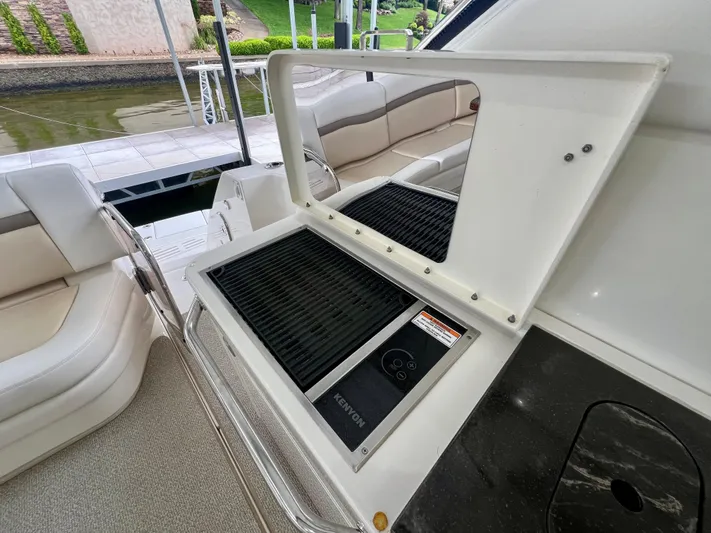  Yacht Photos Pics Outdoor grill on 2014 Sea Ray 410 Sundancer yacht, docked by a serene waterfront.