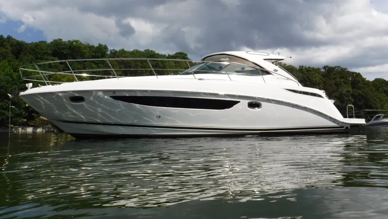  Yacht Photos Pics 2014 Sea Ray 410 Sundancer yacht on calm water, surrounded by lush greenery.