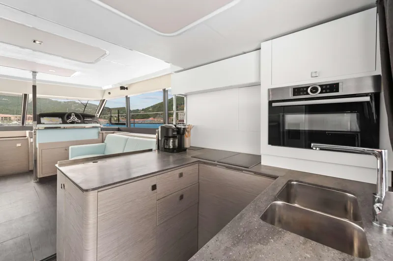 Mona Lisa Yacht Photos Pics Modern kitchen interior of 2024 Fountaine Pajot MY.6 yacht with sleek design and appliances.