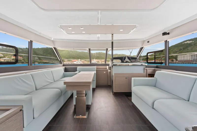 Mona Lisa Yacht Photos Pics Luxurious interior of 2024 Fountaine Pajot MY.6 yacht with panoramic windows and modern seating.