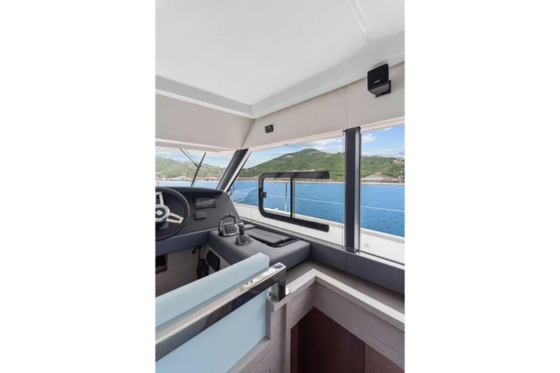 Mona Lisa Yacht Photos Pics Interior view of 2024 Fountaine Pajot MY.6 yacht helm with ocean and mountain backdrop.