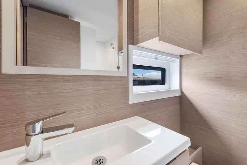 Mona Lisa Yacht Photos Pics Modern bathroom interior of 2024 Fountaine Pajot MY.6 yacht with sleek sink and window.