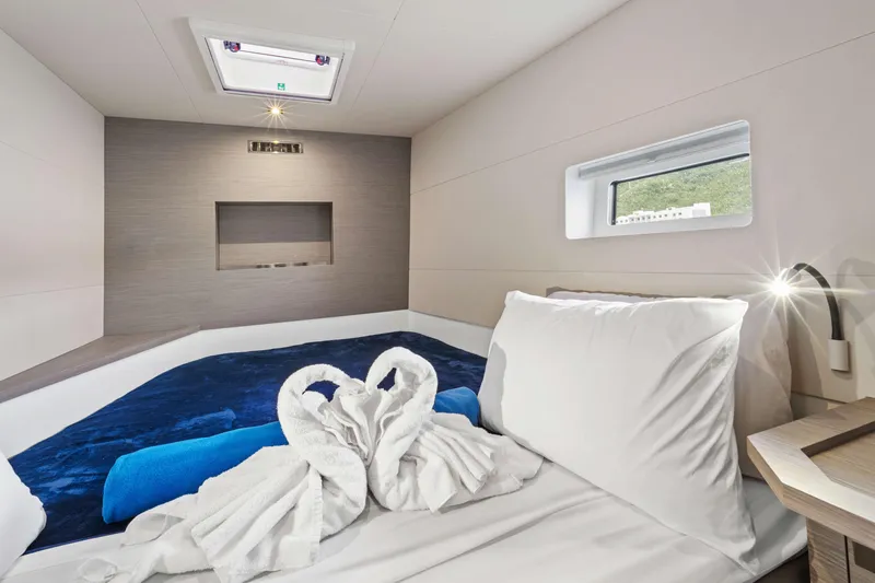 Mona Lisa Yacht Photos Pics Luxurious cabin interior of 2024 Fountaine Pajot MY.6 yacht with elegant bedding and window view.