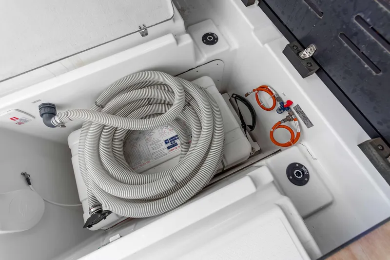 Mona Lisa Yacht Photos Pics 2024 Fountaine Pajot MY.6 yacht compartment with coiled hose and equipment.
