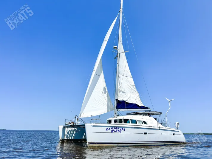 Kansakota Winds Yacht Photos Pics 2003 Lagoon 410-S2 catamaran sailing on calm waters under clear blue sky.