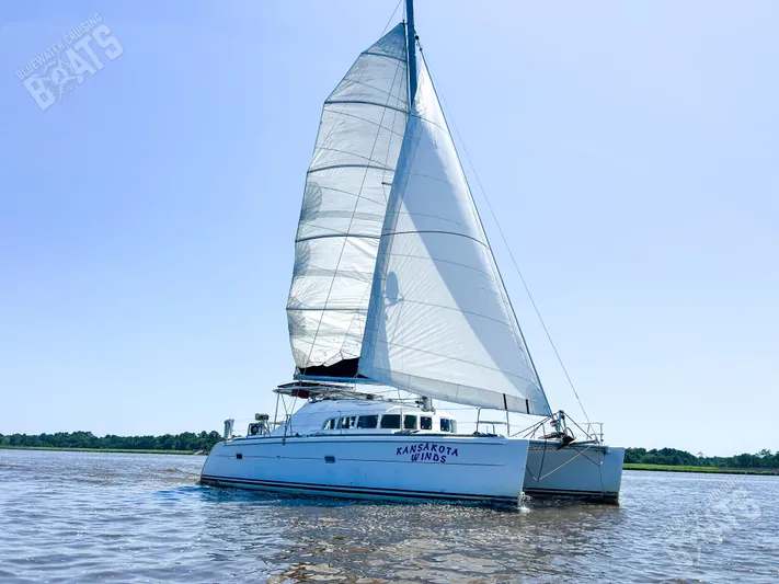 Kansakota Winds Yacht Photos Pics 2003 Lagoon 410-S2 catamaran sailing on calm waters under clear blue skies.