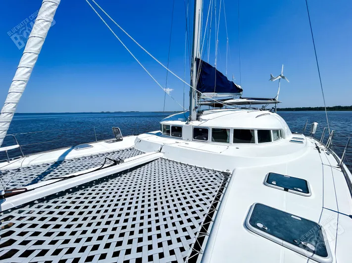 Kansakota Winds Yacht Photos Pics 2003 Lagoon 410-S2 catamaran on calm waters under clear blue sky.