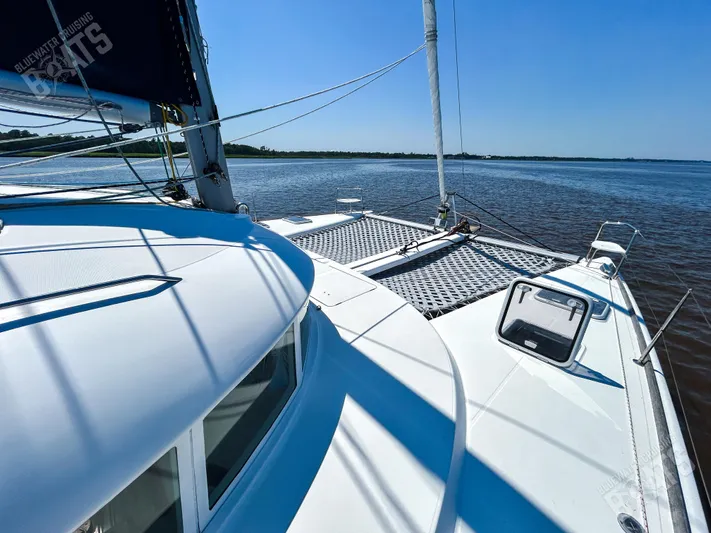 Kansakota Winds Yacht Photos Pics 2003 Lagoon 410-S2 catamaran sailing on calm waters under clear blue skies.