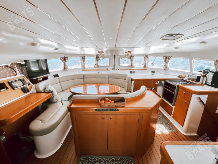 Kansakota Winds Yacht Photos Pics Luxurious interior of 2003 Lagoon 410-S2 catamaran with elegant seating and modern kitchen.