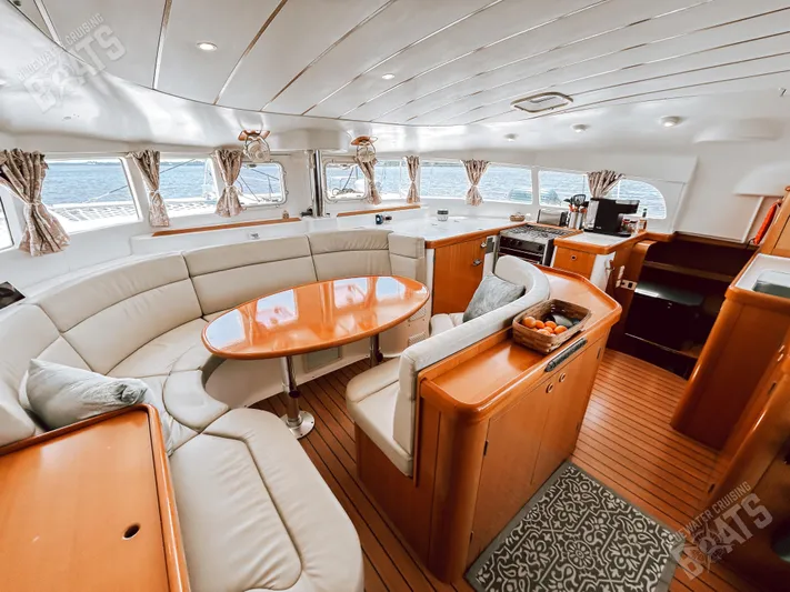 Kansakota Winds Yacht Photos Pics Luxurious interior of 2003 Lagoon 410-S2 catamaran with elegant seating and modern kitchen.