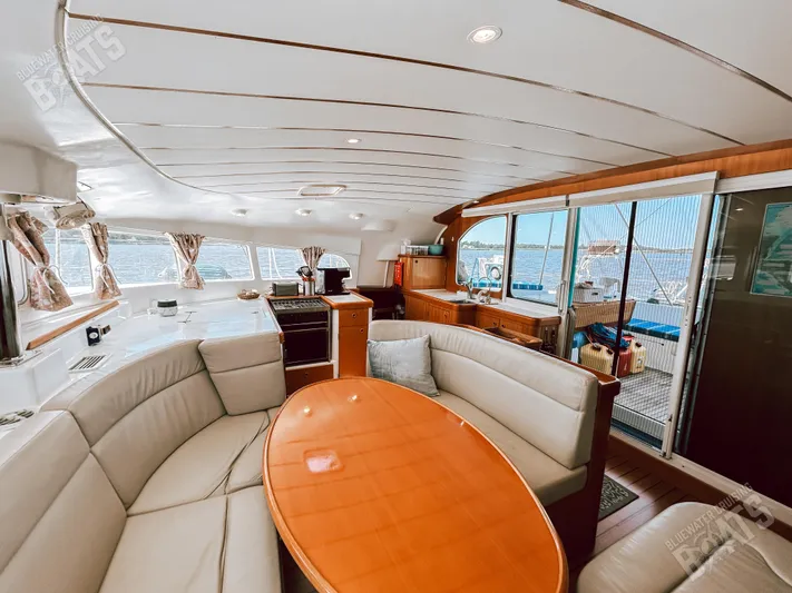Kansakota Winds Yacht Photos Pics Luxurious interior of 2003 Lagoon 410-S2 catamaran with elegant seating and panoramic windows.