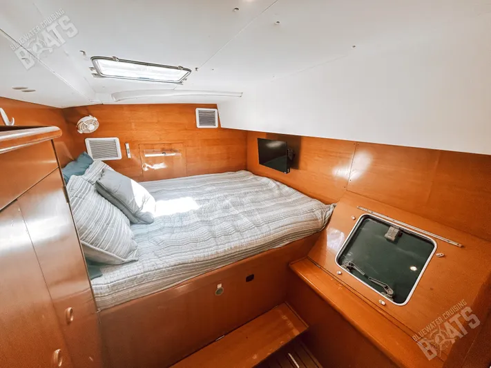 Kansakota Winds Yacht Photos Pics Cozy cabin interior of 2003 Lagoon 410-S2 catamaran with bed and porthole.