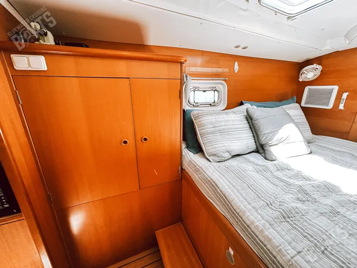 Kansakota Winds Yacht Photos Pics Interior of 2003 Lagoon 410-S2 yacht cabin with wooden cabinetry and cozy bedding.