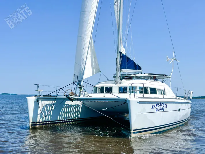 Kansakota Winds Yacht Photos Pics 2003 Lagoon 410-S2 catamaran sailing on calm waters under clear blue sky.